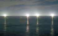 真っ暗な夜の空と海を照らす漁り火